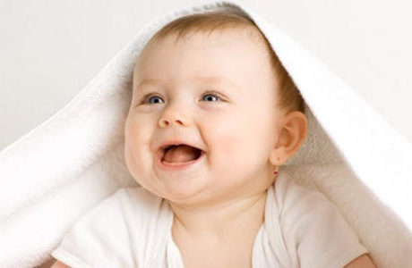 お布団をかぶって笑顔の赤ちゃん